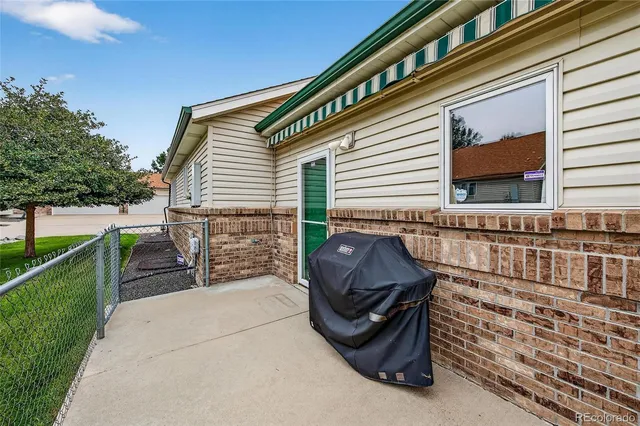 a view of a chair and tables in the back yard of the house