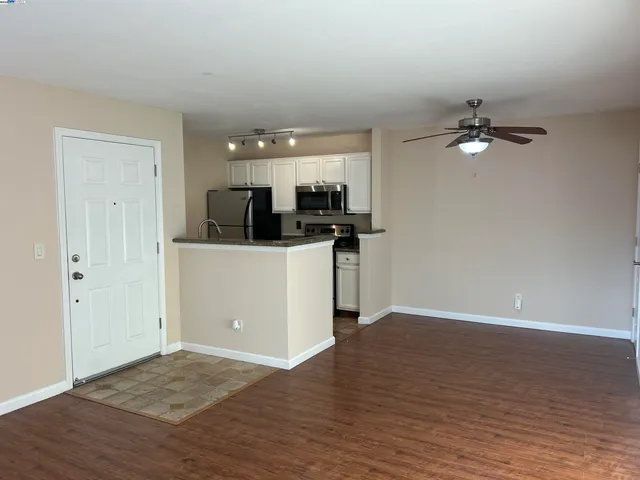 a view of a kitchen with wooden floor and a ceiling fan
