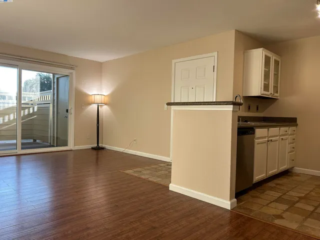 a view of a kitchen with wooden floor electronic appliances and windows