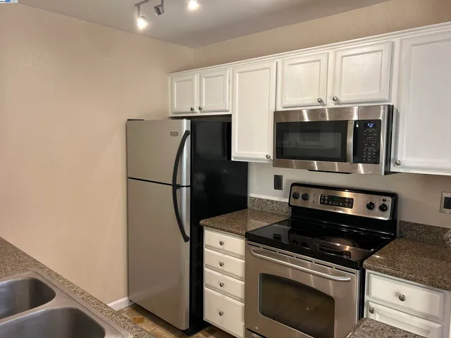 a kitchen with stainless steel appliances a refrigerator stove and microwave