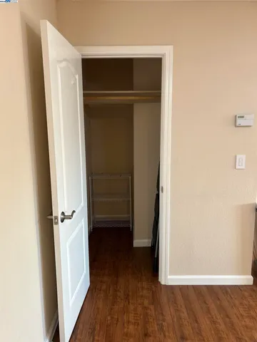 an empty room with wooden floor and closet