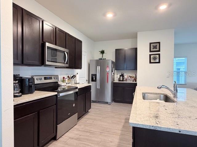 5175 Southwest 47th Lane Gainesville, FL 32608 - Photo 12 of 24 a large kitchen with kitchen island granite countertop a sink dishwasher stove and refrigerator with wooden floor