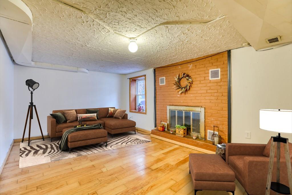 40 Truman Circle Springfield, MA 01109 - Photo 10 of 13 a living room with furniture a fireplace and a flat screen tv