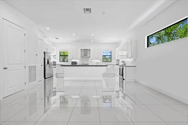 a kitchen with stainless steel appliances granite countertop a refrigerator sink and cabinets