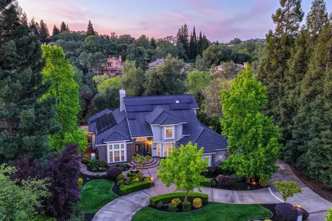 an aerial view of a house with a yard and outdoor seating