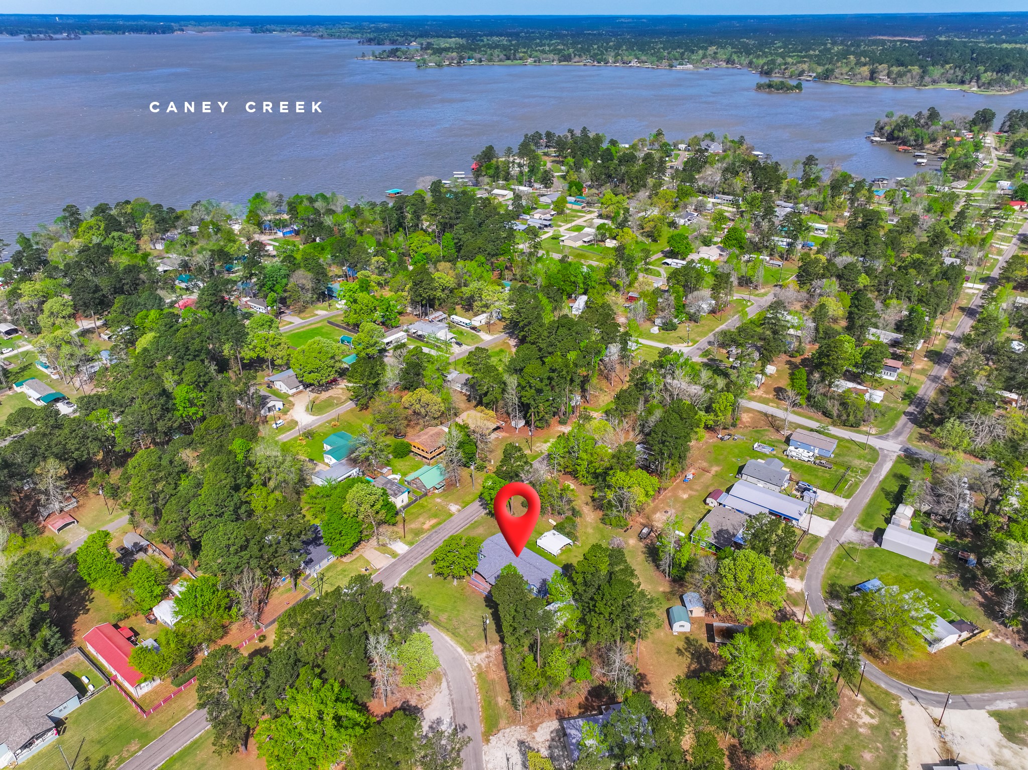 115 Canadian Drive Trinity, TX 75862 - Photo 1 of 41 This aerial photo showcases a charming neighborhood, surrounded by lush greenery and close proximity to the water. The area is serene and ideal for homebuyers seeking a peaceful, nature-filled environment.