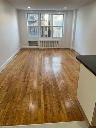 wooden floor in a room next to a window
