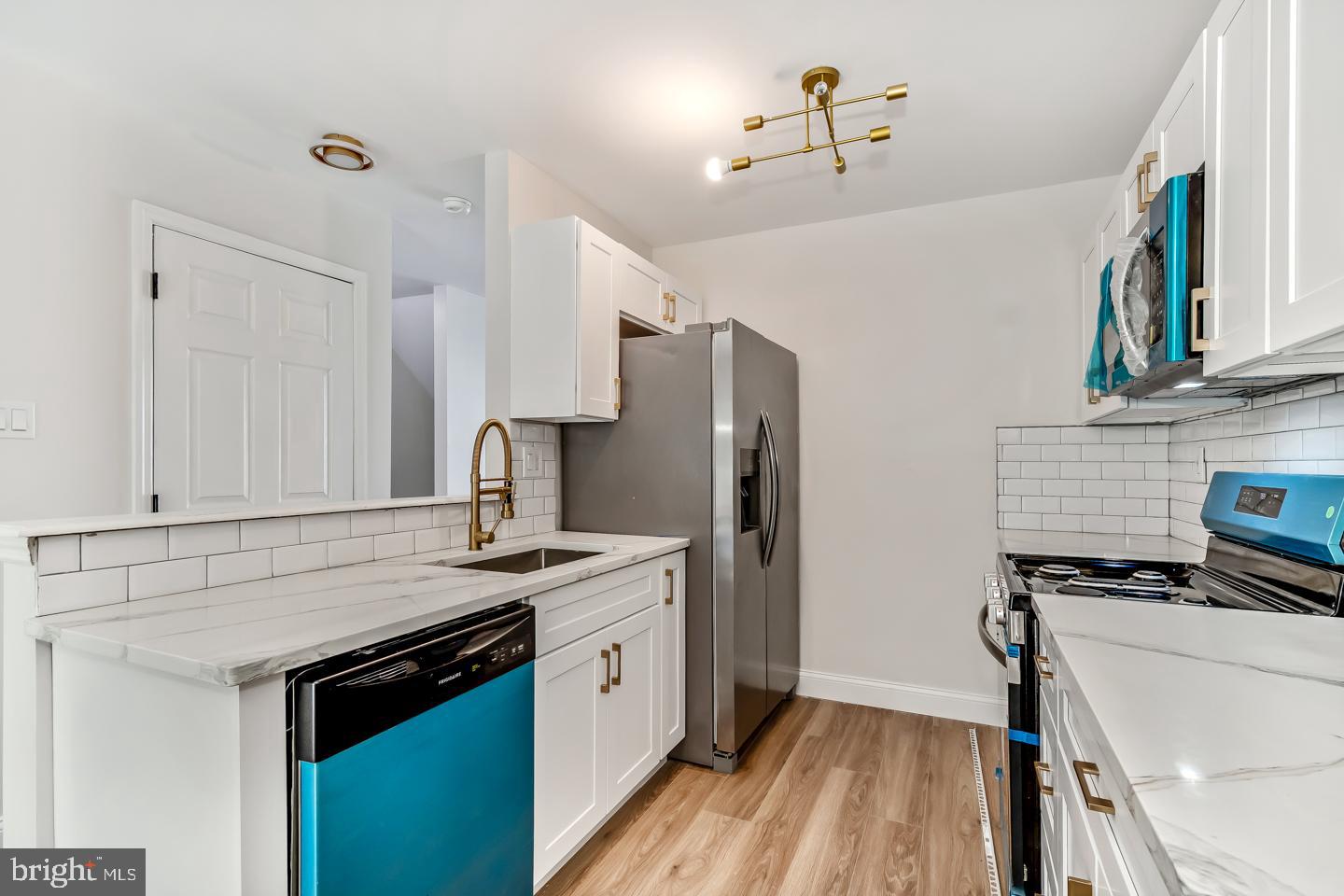 24 Mill Court Pine Hill, NJ 08021 - Photo 6 of 19 a kitchen with stainless steel appliances a stove a sink and a refrigerator