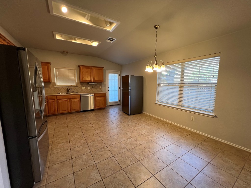 9301 Muskberry Cove Austin, TX 78717 - Photo 6 of 23 a kitchen with refrigerator and cabinets