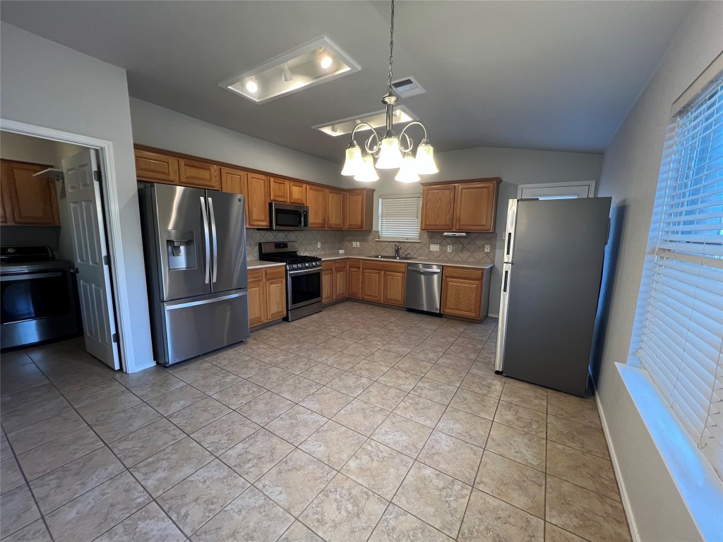 9301 Muskberry Cove Austin, TX 78717 - Photo 7 of 23 a kitchen with refrigerator and microwave