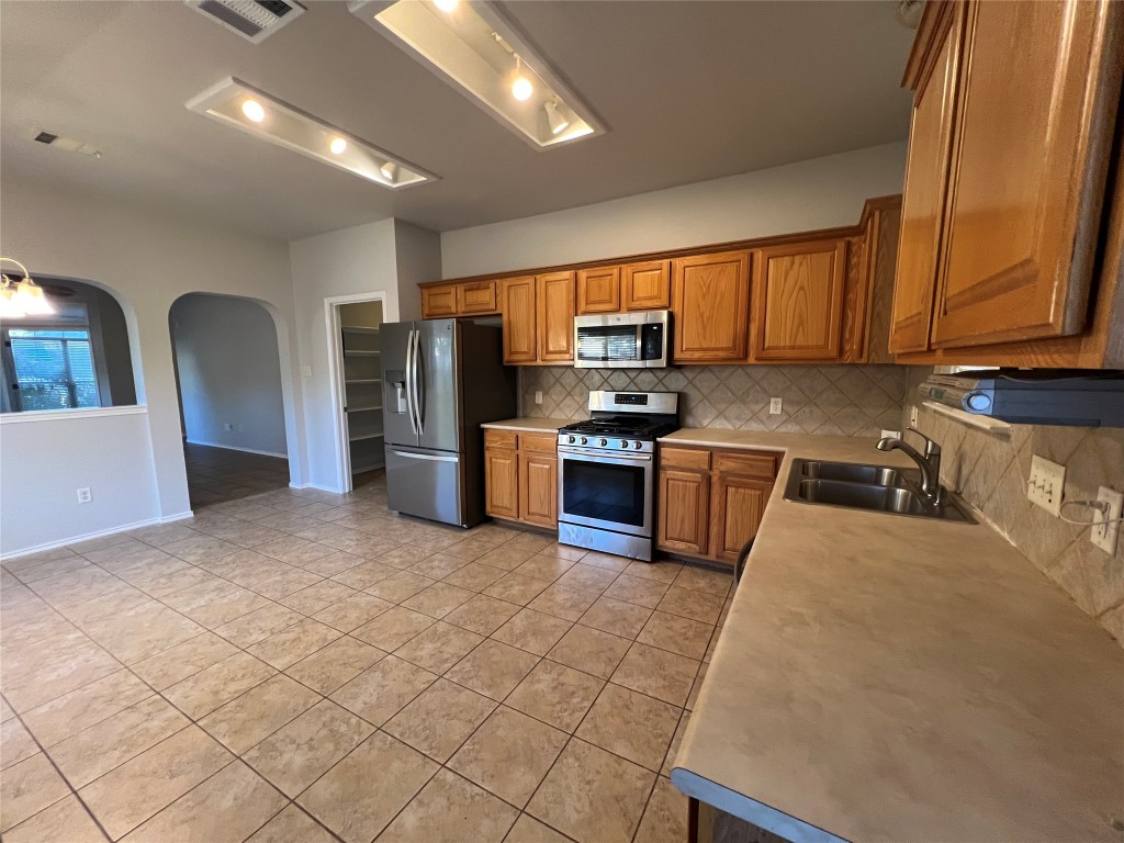 9301 Muskberry Cove Austin, TX 78717 - Photo 8 of 23 a kitchen with stainless steel appliances granite countertop a stove a sink dishwasher a refrigerator and cabinets with wooden floor