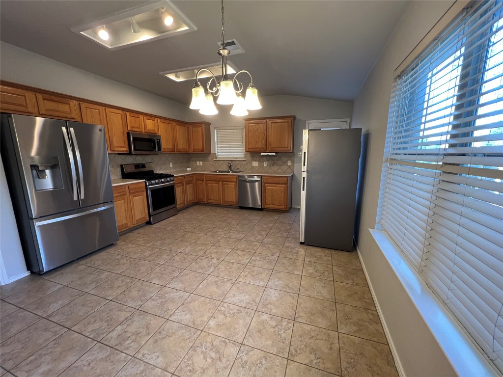 9301 Muskberry Cove Austin, TX 78717 - Photo 9 of 23 a large kitchen with cabinets and stainless steel appliances