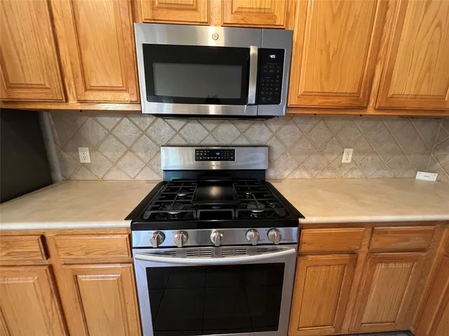a kitchen with wooden cabinets and a stove top oven