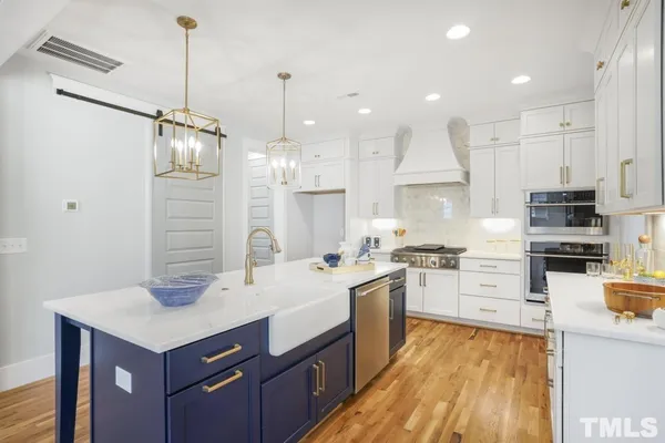 a kitchen with stainless steel appliances kitchen island granite countertop a sink stove and refrigerator