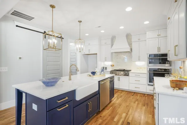 a kitchen with stainless steel appliances kitchen island granite countertop a sink stove and refrigerator