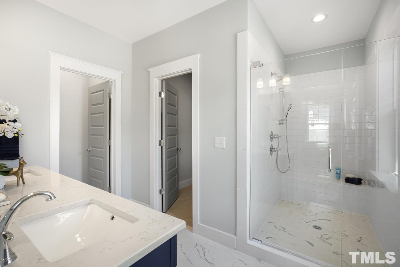 1017 Terrabella Way Durham, NC 27713 - Photo 6 of 8 a bathroom with a shower sink and mirror