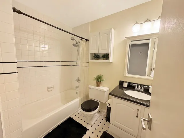 a bathroom with a granite countertop sink a toilet and bathtub