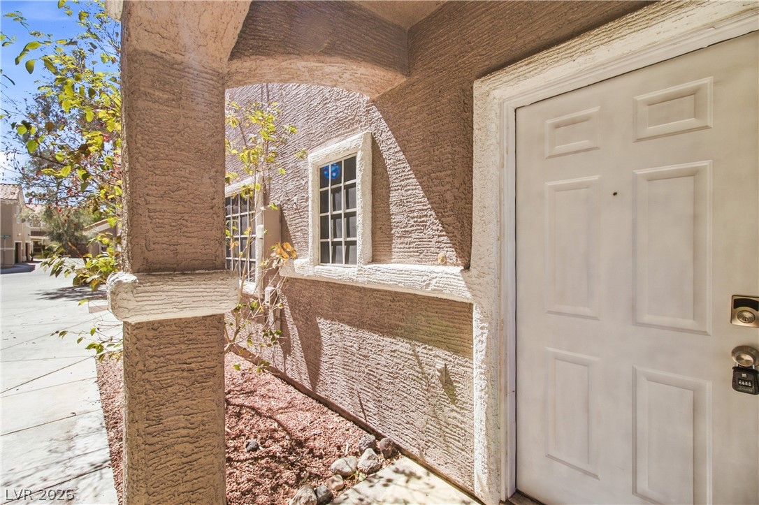 1475 Reef Ridge Court Las Vegas, NV 89128 - Photo 3 of 24 Stucco pillars and an arched entryway frame the welcoming front entrance.