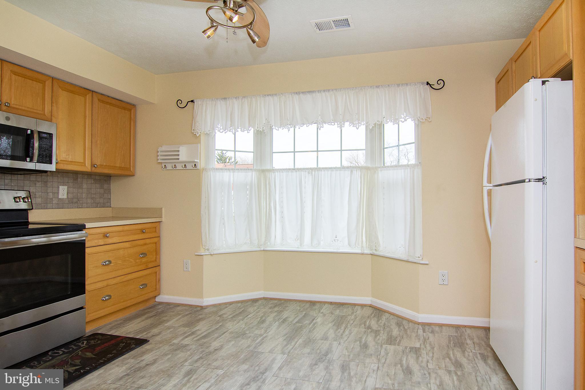 840 Century Street Hampstead, MD 21074 - Photo 12 of 34 a kitchen with a refrigerator a stove a microwave and cabinets