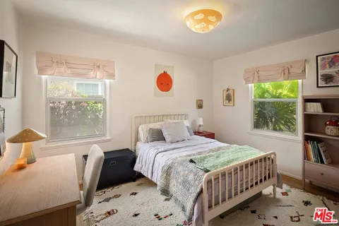 a bedroom with a bed and a wooden floor