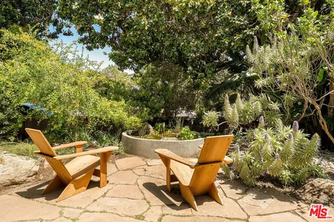 a backyard of a house with garden and outdoor seating