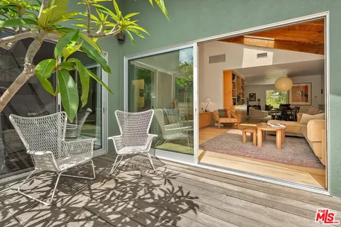 a view of a backyard with plants and a bench