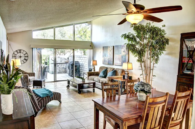 a living room with furniture a chandelier and a floor to ceiling window