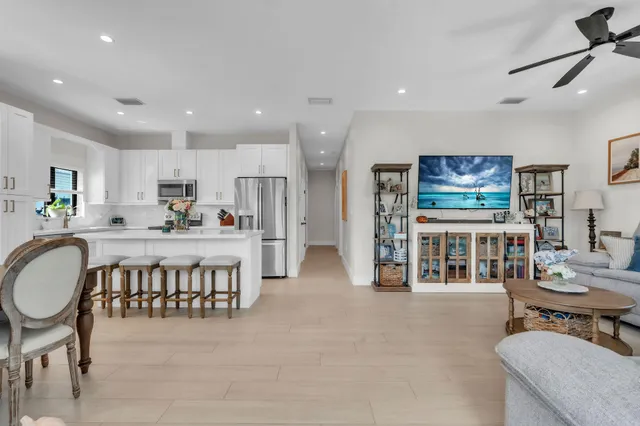 a kitchen with stainless steel appliances a table and chairs in it