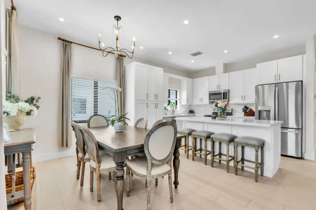 a kitchen with kitchen island a dining table and chairs