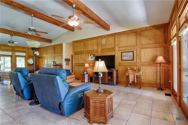 a living room with furniture a flat screen tv and large window