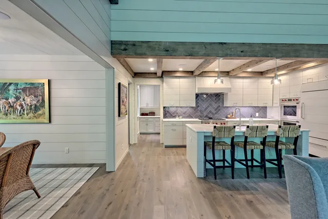 a kitchen with stainless steel appliances granite countertop a stove top oven a sink dishwasher and wooden cabinets with wooden floor