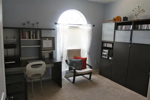 a view of a workspace with furniture and a window