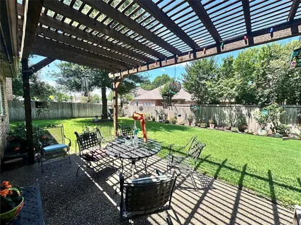 a view of a patio with table and chairs potted plants and large tree
