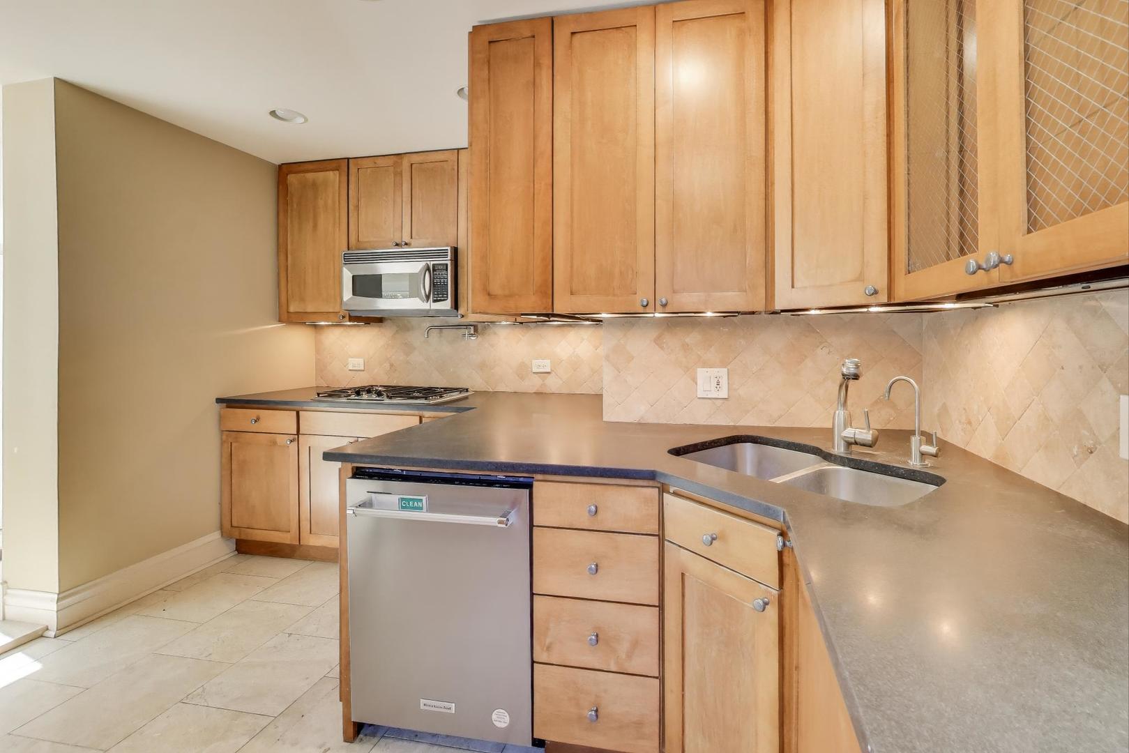 1020 Harvard Terrace Evanston, IL 60202 - Photo 11 of 31 a kitchen with stainless steel appliances granite countertop a sink a stove and a microwave