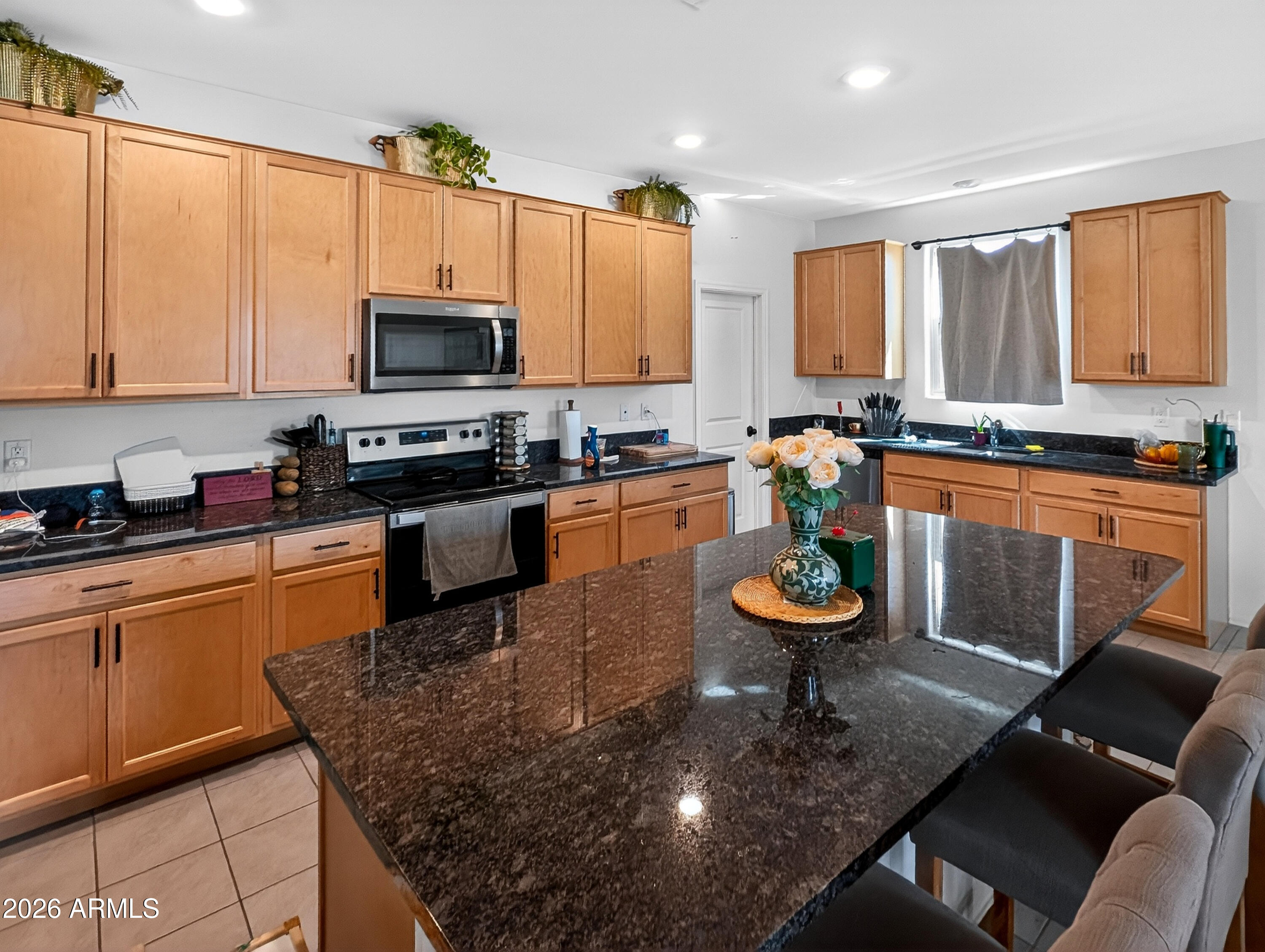 2439 West Pecan Road Phoenix, AZ 85041 - Photo 17 of 38 a kitchen with stainless steel appliances granite countertop a stove top oven a sink dishwasher a dining table and chairs with wooden floor