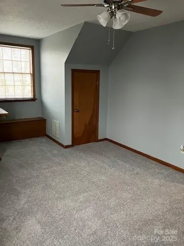 an empty room with a ceiling fan and a window