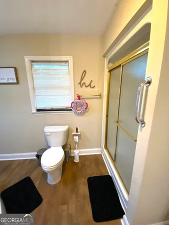 a bathroom with a sink a toilet a shower a vanity and a mirror