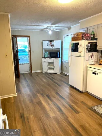a living room with stainless steel appliances furniture and a kitchen view