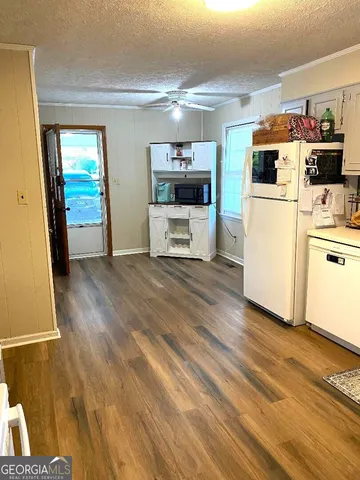a living room with stainless steel appliances furniture and a kitchen view