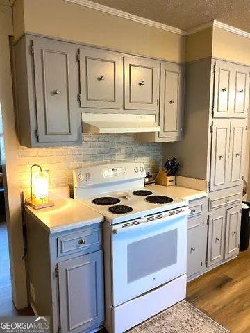 a kitchen with granite countertop a sink stove and cabinets