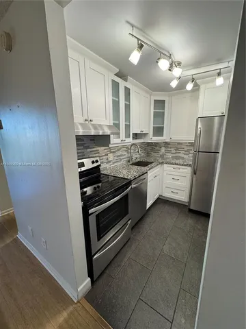 a kitchen with stainless steel appliances granite countertop a stove and a refrigerator