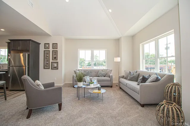a living room with furniture a flat screen tv and a window