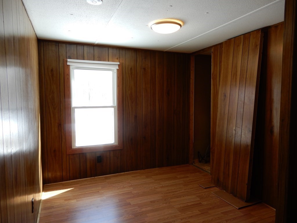 1 Heritage Drive Warren, MA 01585 - Photo 14 of 20 an empty room with wooden floor and windows
