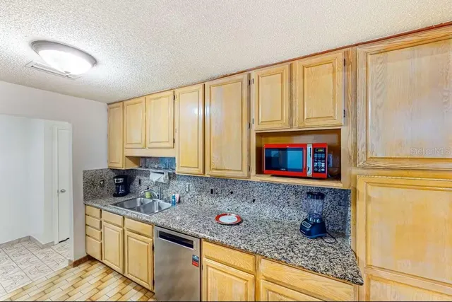 a kitchen with stainless steel appliances granite countertop a sink a stove and cabinets