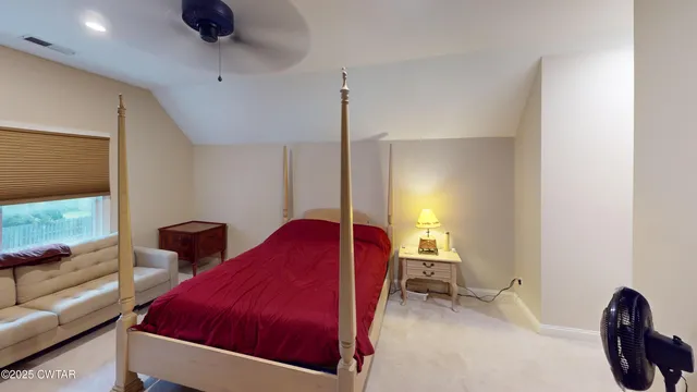 a bedroom with a bed and a lamp on dresser