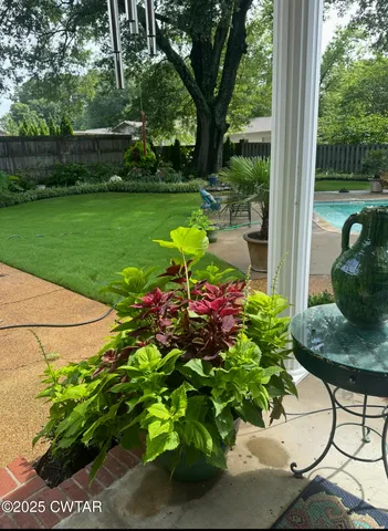 a flower garden with a bench in front of the house