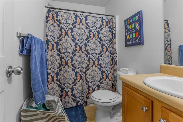 a bathroom with a toilet and a shower curtain