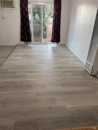 a view of a room with wooden floor and a window