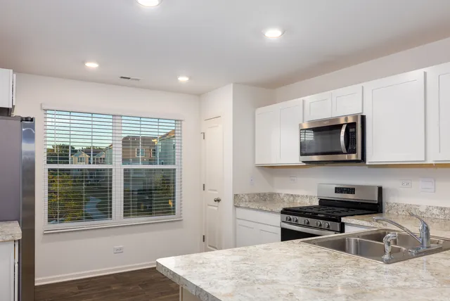 a kitchen with granite countertop a stove and a sink
