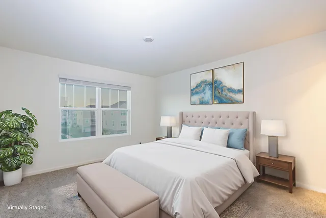 a bedroom with a large bed and a potted plant